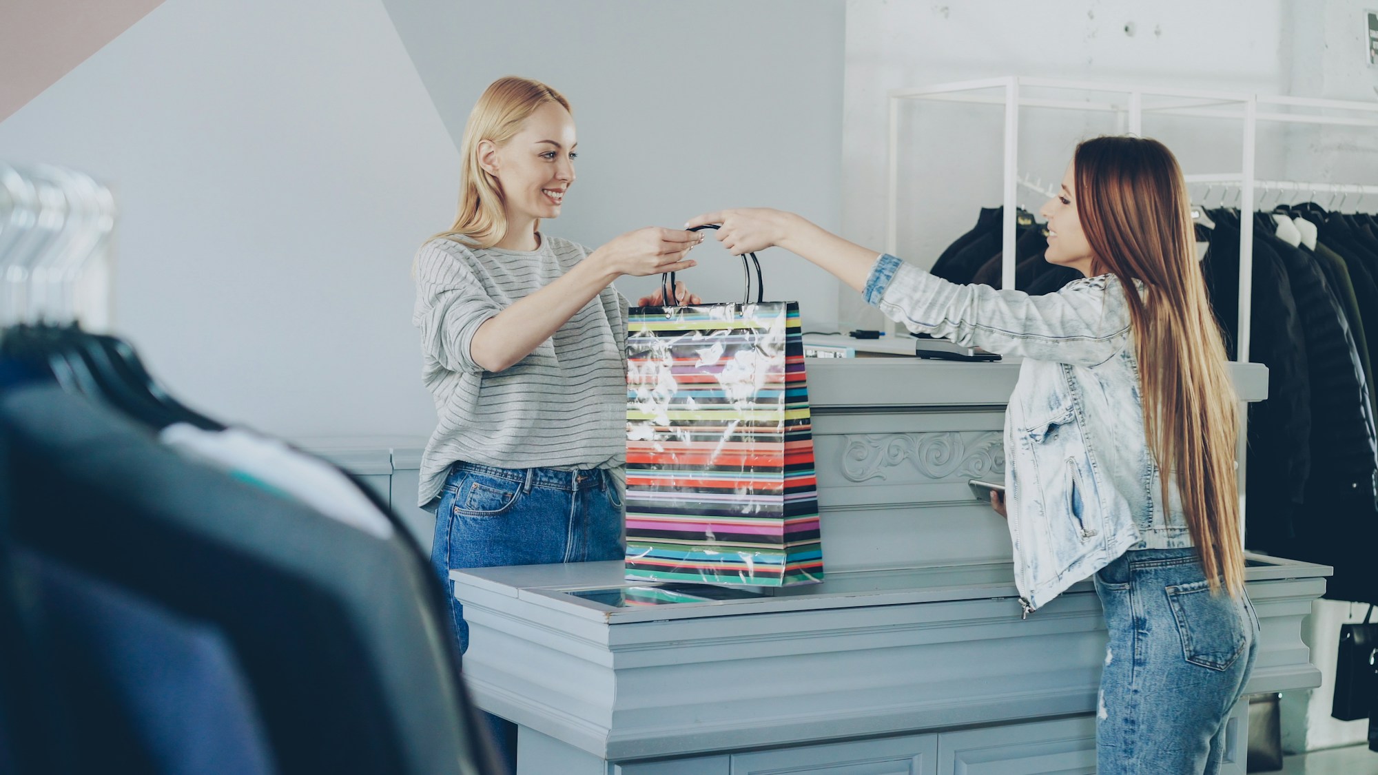 A customer receiving a shopping bag at a store counter